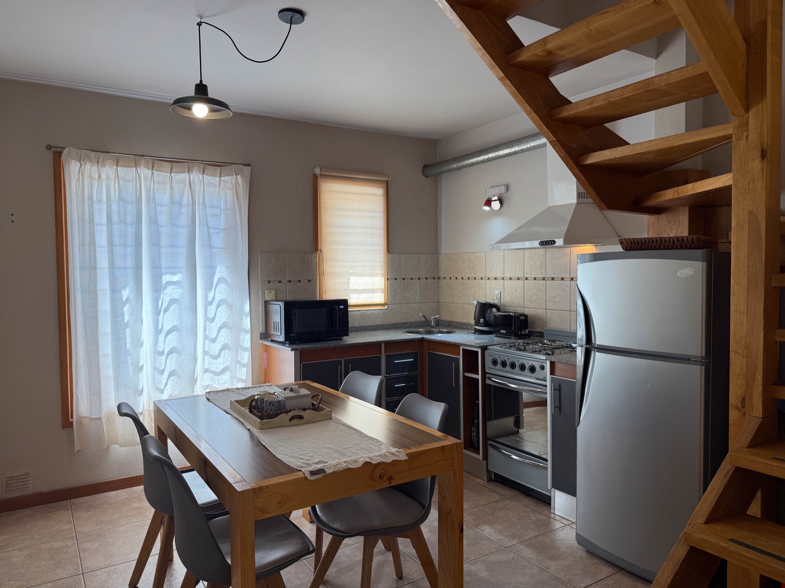 Cocina americana con escalera de madera al altillo