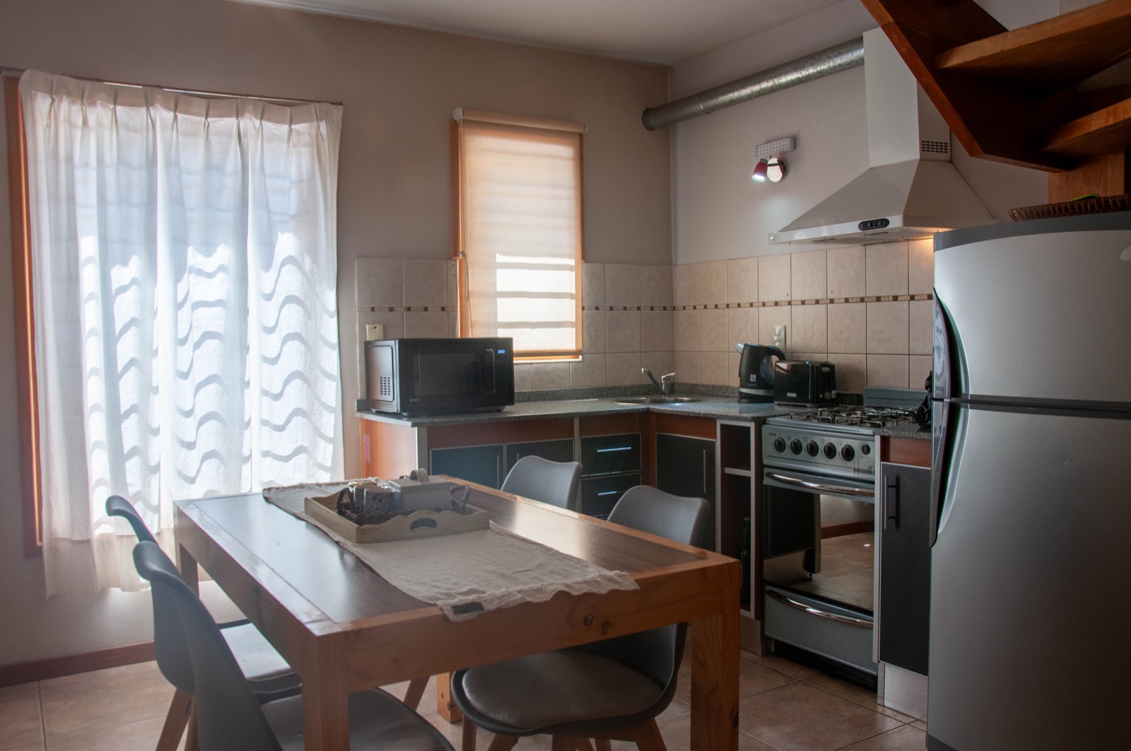 Cocina americana equipada con heladera, horno, microondas y comedor