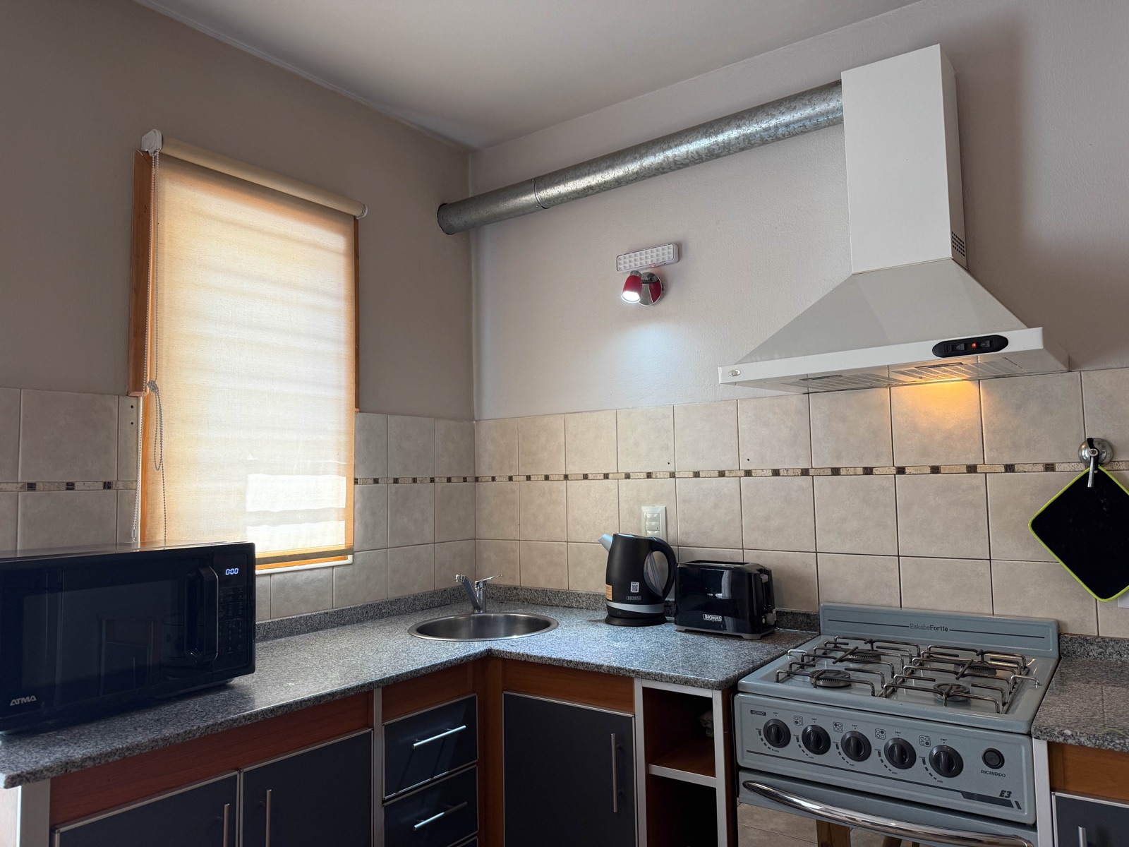 Detalle de la cocina: campana, cafetera eléctrica, pava y tostadora