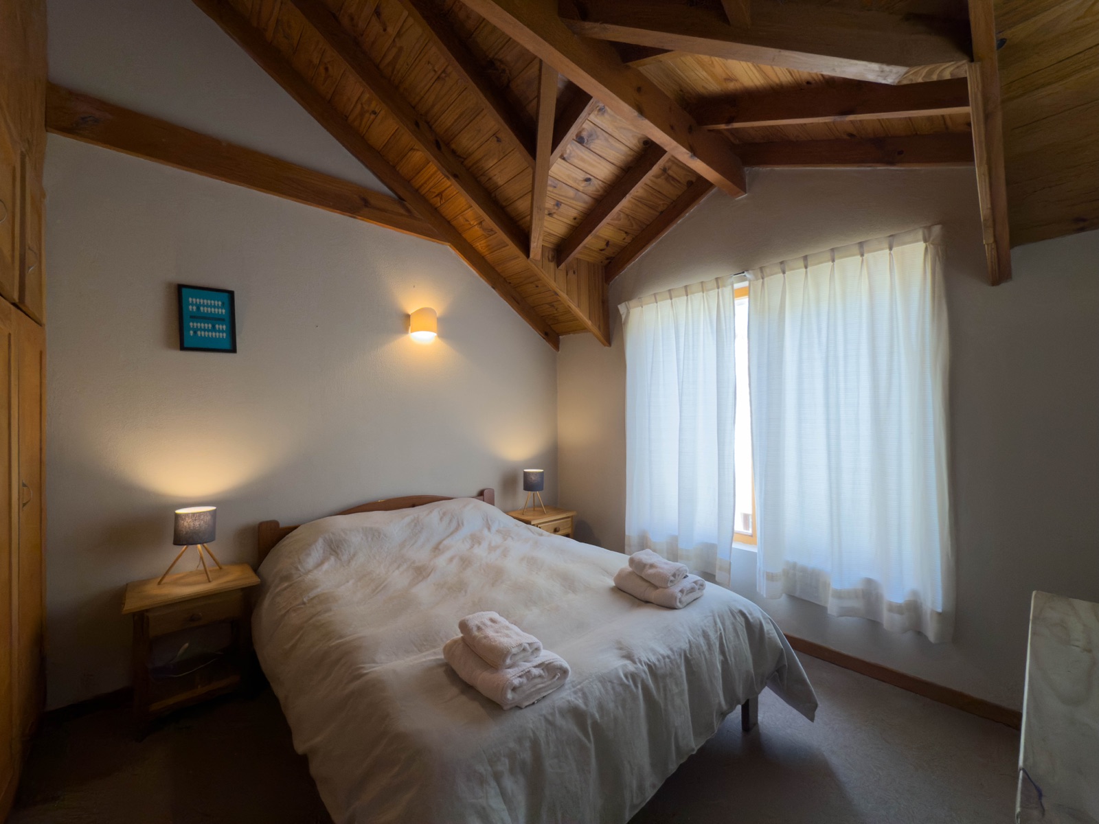 Dormitorio matrimonial con techo de vigas de madera