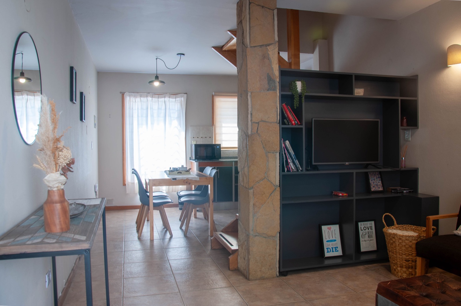 Living-comedor de Paimun 2 con biblioteca, escalera y mesa para comer