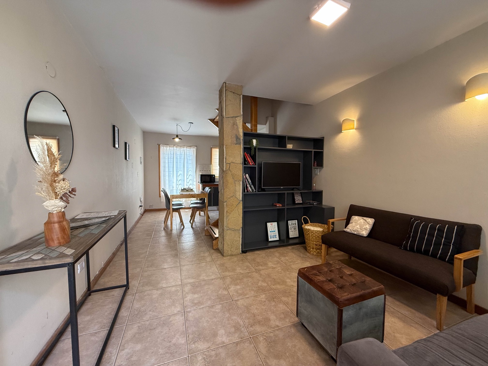 Living amplio de Paimun 2 con sofás, mesa de comedor y biblioteca